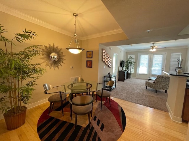 dining space with ceiling fan, ornamental molding, and light hardwood / wood-style floors