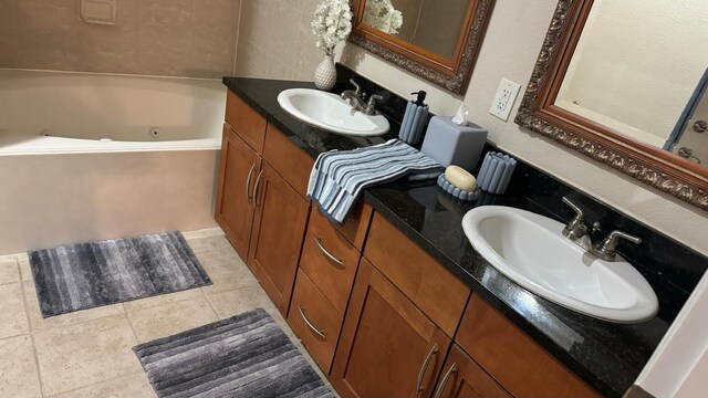 bathroom with vanity, a bathtub, and tile patterned flooring