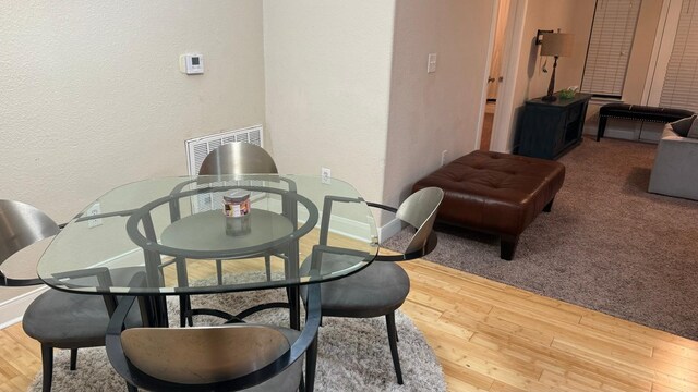 dining space with wood-type flooring