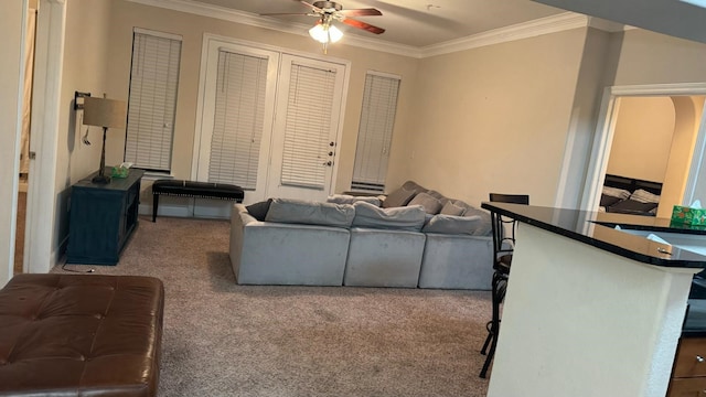 living room featuring ornamental molding, carpet, and ceiling fan