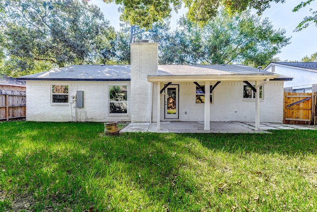 rear view of house featuring a yard and a patio area