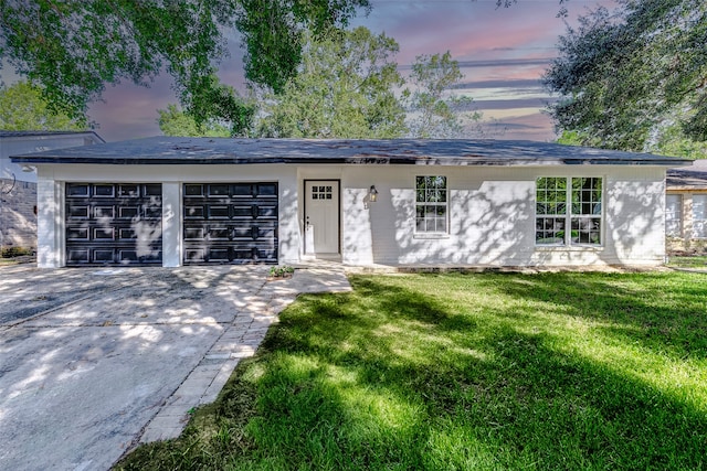 view of front of house with a garage and a yard