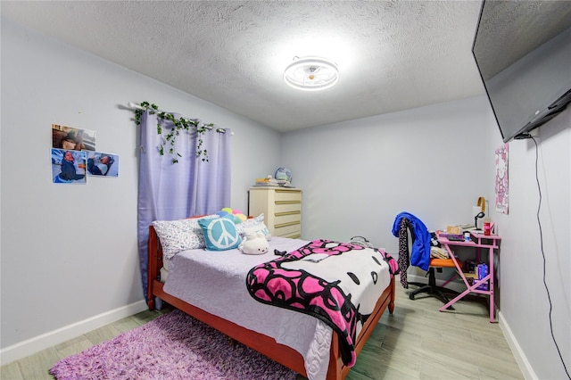 bedroom featuring hardwood / wood-style flooring and a textured ceiling