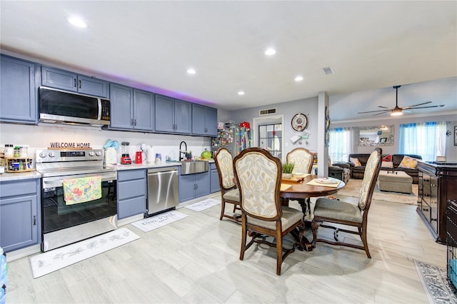 kitchen featuring light hardwood / wood-style floors, sink, stainless steel appliances, blue cabinets, and ceiling fan