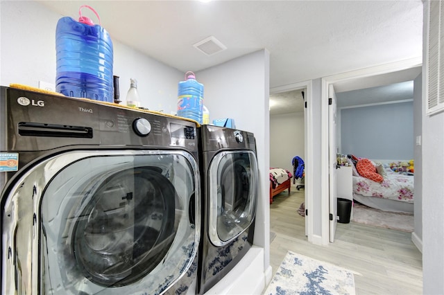 washroom with separate washer and dryer and light wood-type flooring