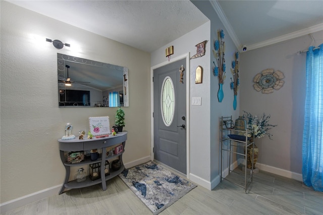 foyer with ornamental molding, vaulted ceiling, ceiling fan, and hardwood / wood-style floors