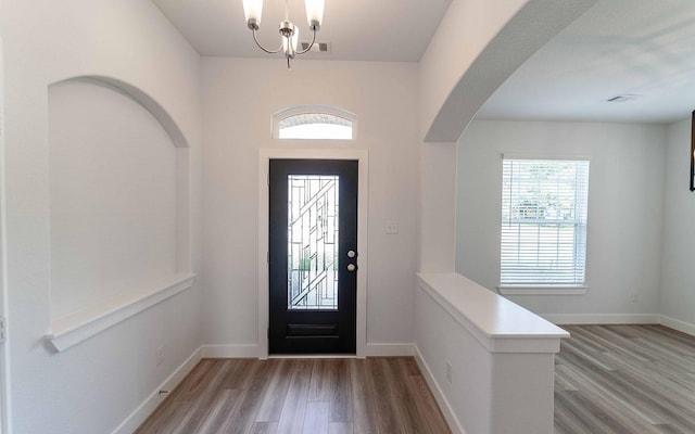 entrance foyer featuring hardwood / wood-style floors and a notable chandelier