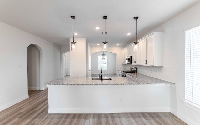 kitchen with plenty of natural light, sink, kitchen peninsula, and stainless steel appliances