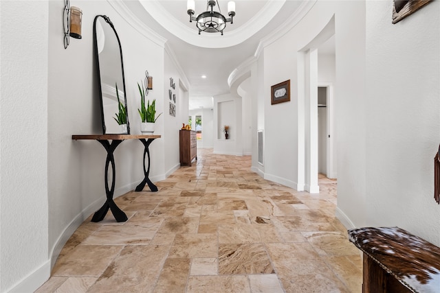 hall with ornamental molding and an inviting chandelier