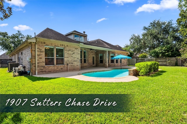 back of property with a patio, a yard, and a fenced in pool