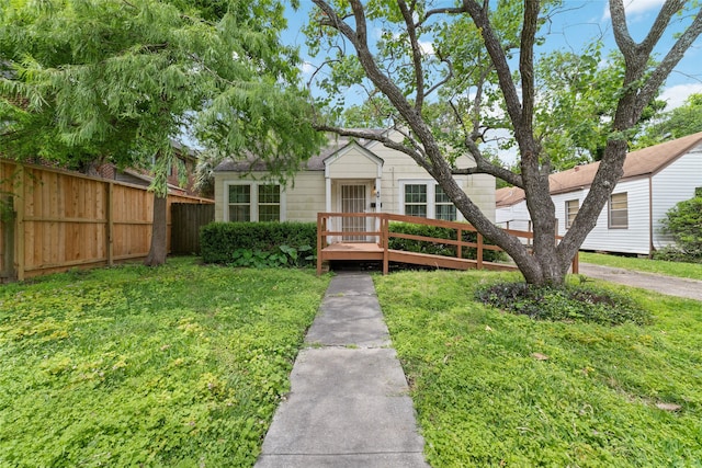 view of front of property featuring a wooden deck and a front yard