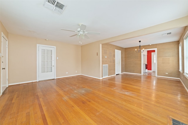 unfurnished room featuring ceiling fan with notable chandelier and hardwood / wood-style flooring