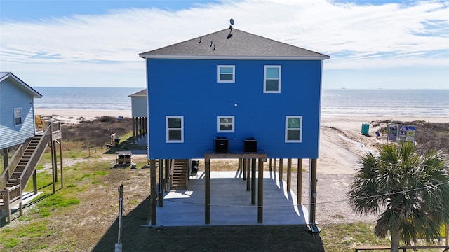 846 Alma, Crystal Beach, TX 77650 - rear view of house with stairs, a carport, view of water and beach, central AC, and dirt driveway