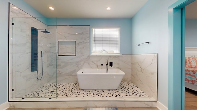 bathroom with shower with separate bathtub and wood-type flooring