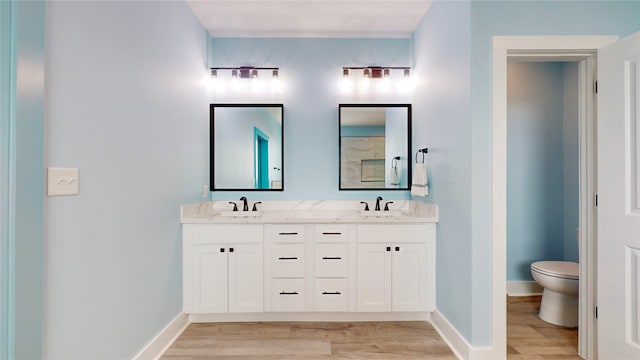 bathroom with hardwood / wood-style floors, vanity, and toilet