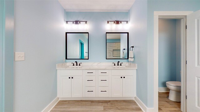 846 Alma, Crystal Beach, TX 77650 - full bathroom with wood finished floors, double vanity, toilet, and baseboards
