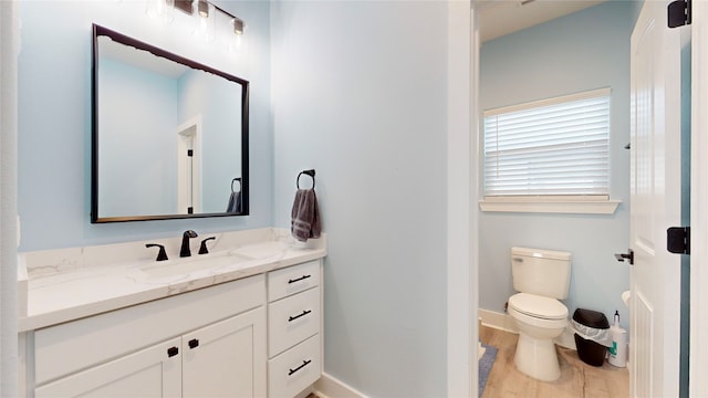 bathroom featuring vanity, toilet, and hardwood / wood-style flooring