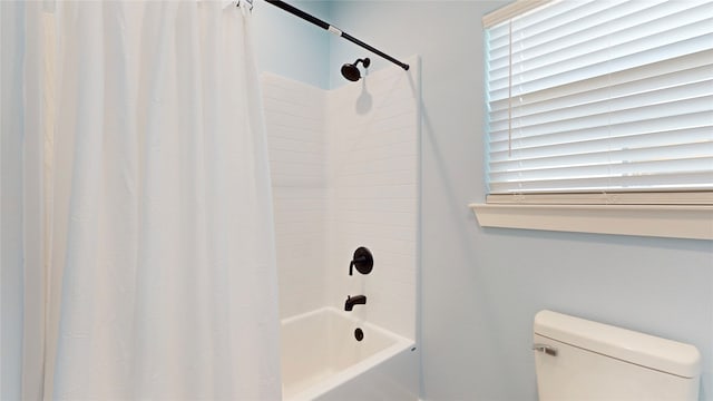 bathroom featuring toilet and shower / bathtub combination with curtain