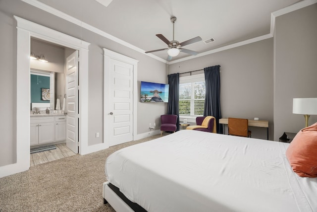 carpeted bedroom with ornamental molding, ensuite bath, ceiling fan, and sink