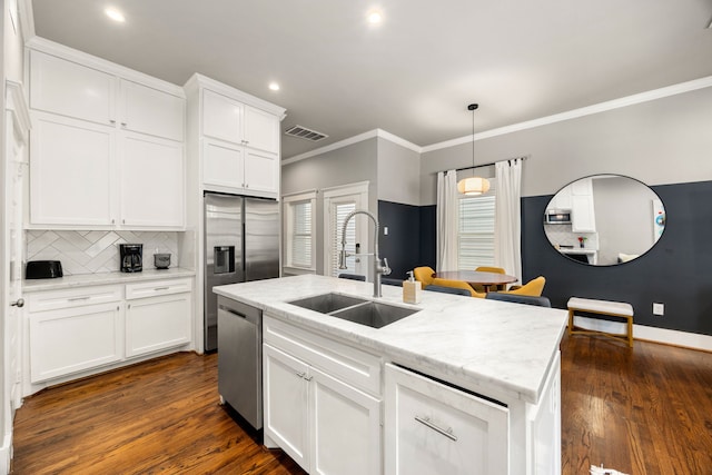 kitchen with sink, a kitchen island with sink, white cabinetry, stainless steel appliances, and dark hardwood / wood-style flooring