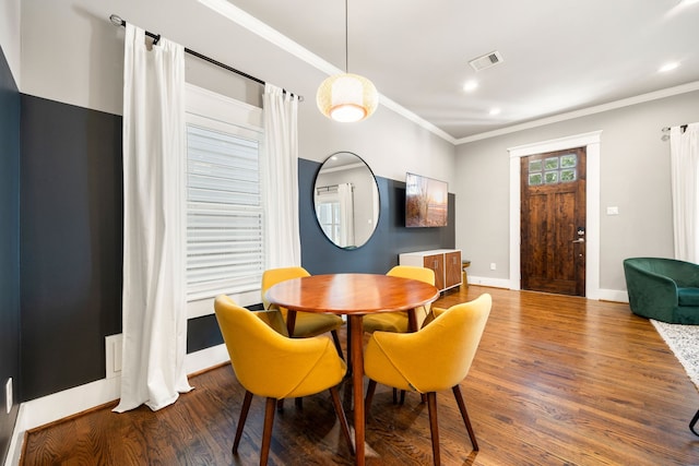 dining area featuring crown molding and hardwood / wood-style floors