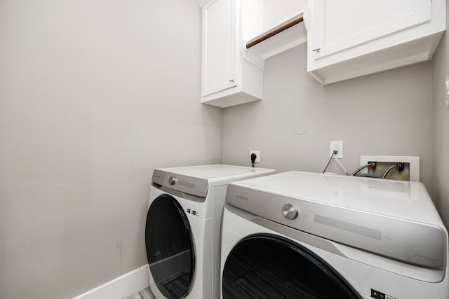 laundry room featuring separate washer and dryer and cabinets