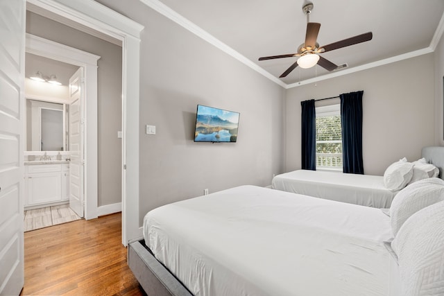 bedroom with wood-type flooring, connected bathroom, crown molding, and ceiling fan