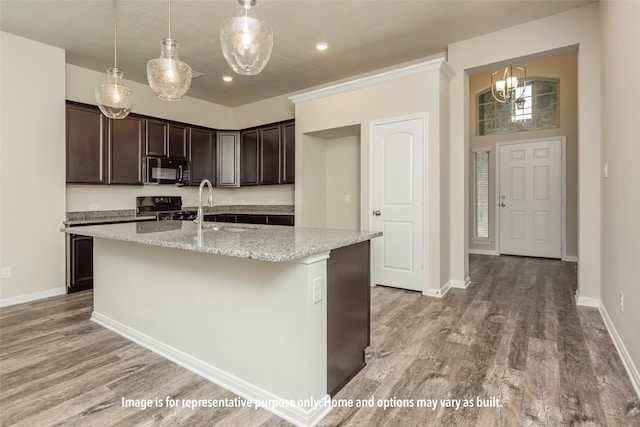 kitchen with light wood-type flooring, a sink, black appliances, and dark brown cabinets