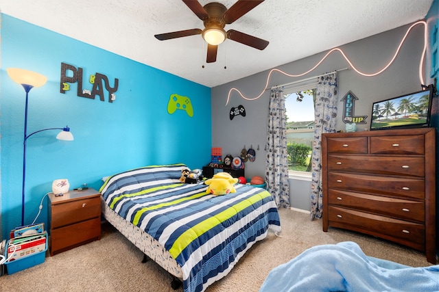 carpeted bedroom with ceiling fan and a textured ceiling