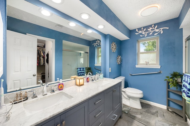 bathroom featuring vanity, a shower with shower door, toilet, and a textured ceiling