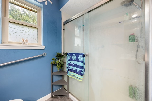 bathroom featuring ceiling fan and a shower with door