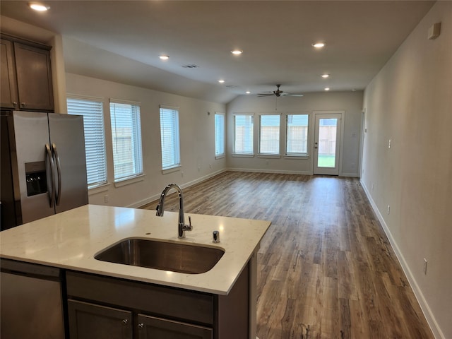 kitchen featuring light stone countertops, vaulted ceiling, dark hardwood / wood-style flooring, and sink