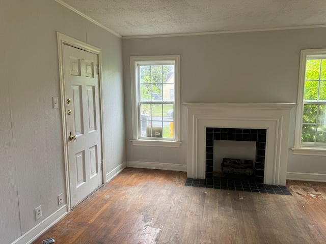 unfurnished living room with a textured ceiling, a fireplace, ornamental molding, and dark hardwood / wood-style flooring