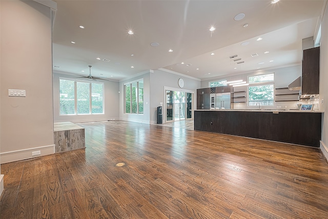 unfurnished living room with ornamental molding, hardwood / wood-style floors, ceiling fan, and sink