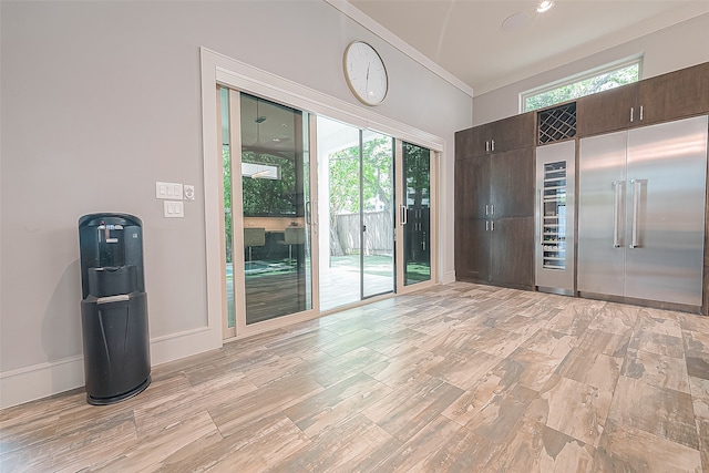 unfurnished room featuring light wood-type flooring and crown molding