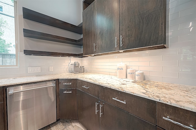 kitchen featuring dark brown cabinetry, dishwasher, light stone countertops, and backsplash