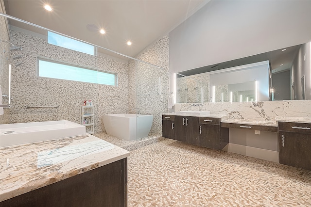 bathroom with vanity, tile walls, shower with separate bathtub, and lofted ceiling