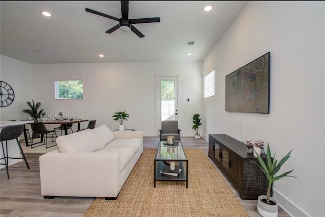 living room with light hardwood / wood-style flooring and ceiling fan