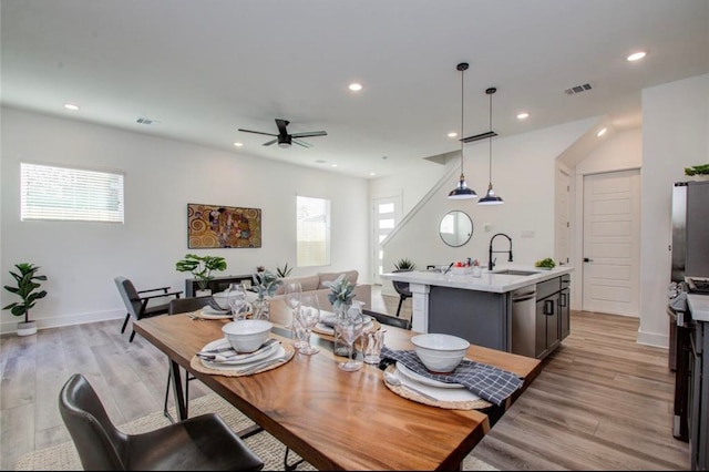 dining area with light wood-type flooring, ceiling fan, a healthy amount of sunlight, and sink