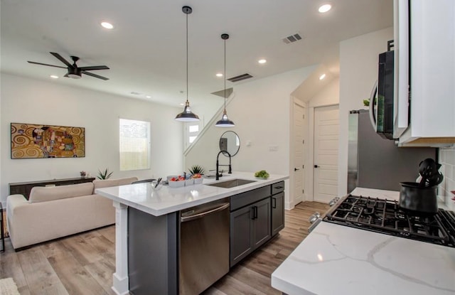 kitchen with ceiling fan, sink, decorative light fixtures, appliances with stainless steel finishes, and light hardwood / wood-style floors