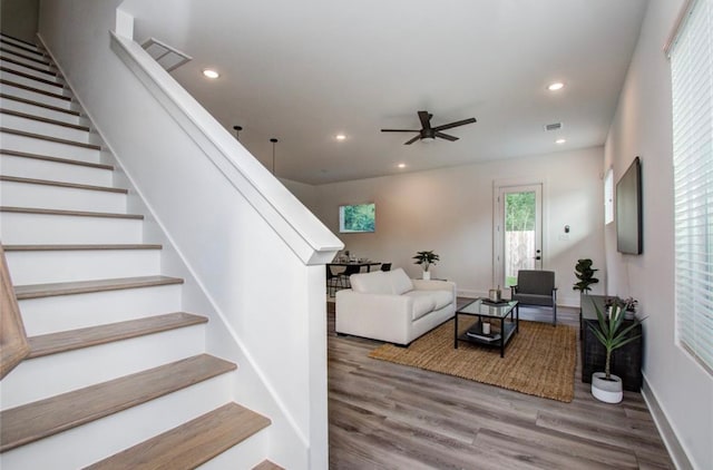 living room with wood-type flooring and ceiling fan