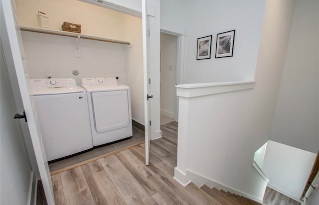 laundry room with washer and dryer and light hardwood / wood-style flooring