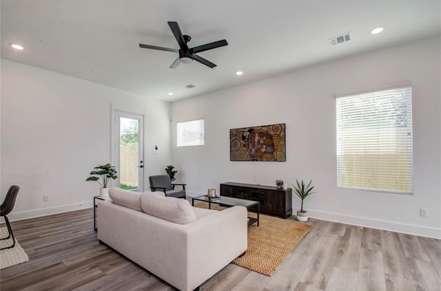 living room with light wood-type flooring and ceiling fan