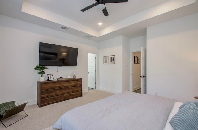 carpeted bedroom featuring ceiling fan and a raised ceiling