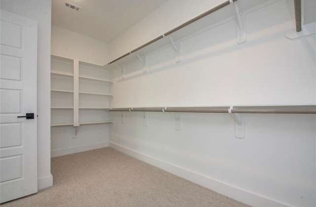 walk in closet featuring light colored carpet