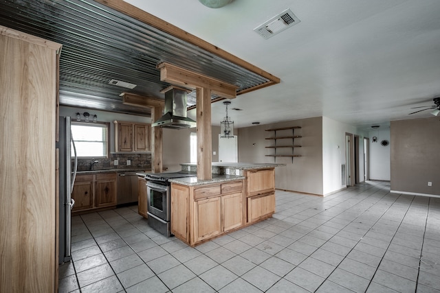 kitchen featuring pendant lighting, wall chimney range hood, appliances with stainless steel finishes, light tile patterned floors, and ceiling fan