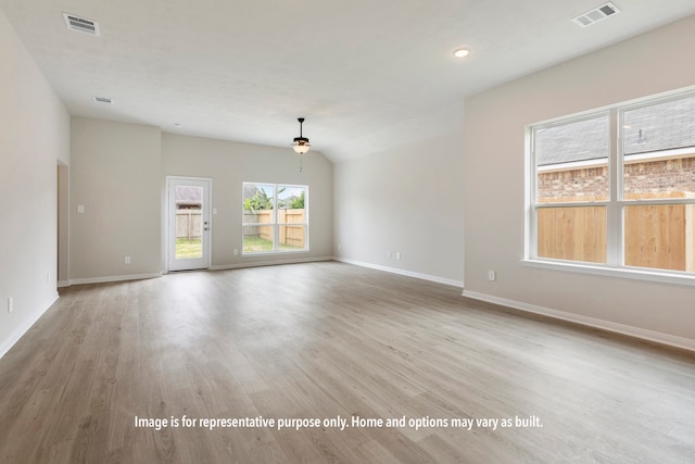 empty room with lofted ceiling and light hardwood / wood-style floors