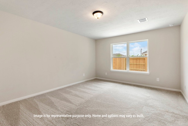 spare room featuring carpet floors and a textured ceiling