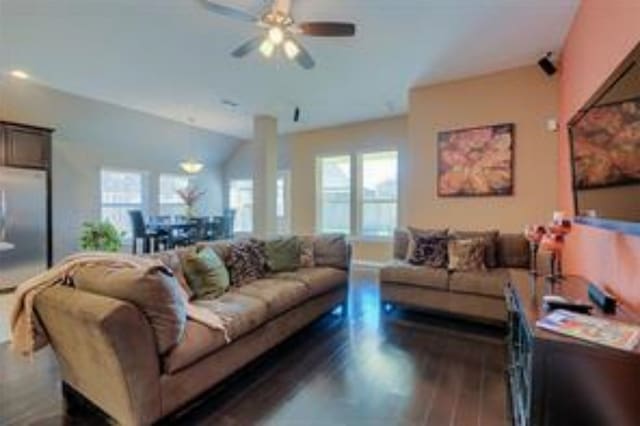 living room with vaulted ceiling, ceiling fan, and dark wood-type flooring