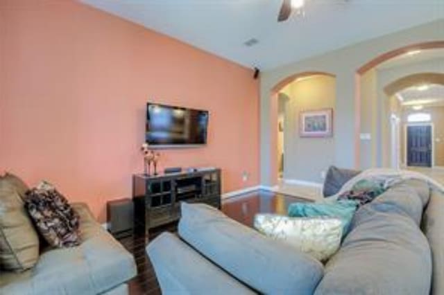 living room featuring wood-type flooring and ceiling fan